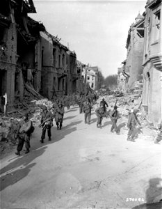 SC 270686 - Men of the 5th Inf. Div., U.S. Third Army, fan out in a street of Worms, Germany, in their search for enemy resistance in the captured city. photo