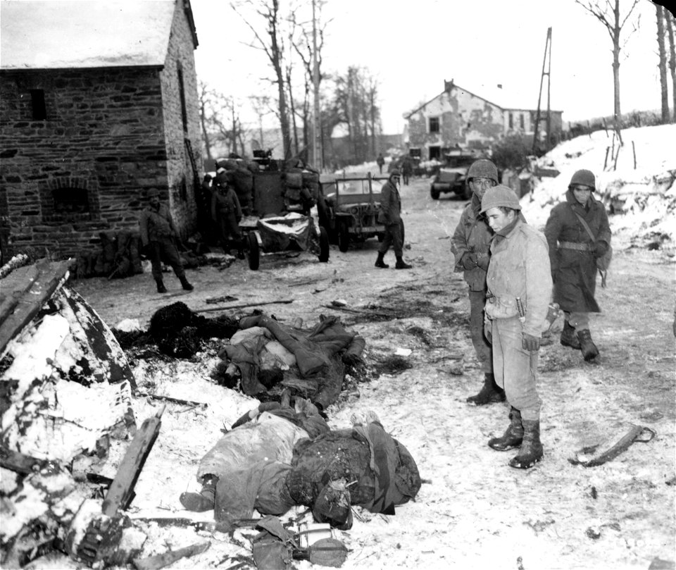 SC 199023 - Yanks of the 83rd Infantry Division look at dead Germans, killed in the Ardennes bulge during First Army drive back into German-held territory on the continent. 13 January, 1945.