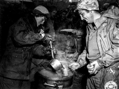 SC 329750 - Pvt. Anthony Bellisola, Leyden St., Medford, Mass., receiving coffee from a member of the American Red Cross.