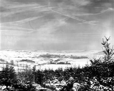 SC 32975 - Enemy-held town of Benonchamps, Belgium, during the attack by the 15th Tank Battalion of the 6th Armored Division. Smoke arises from several fires started. Tanks are advancing through snow-covered fields at left. photo