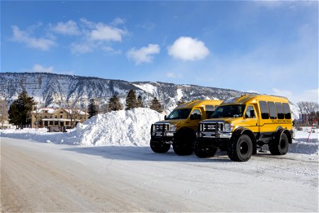 Snowcoaches in front of a pile of snow in Mammoth Hot Springs (3) photo