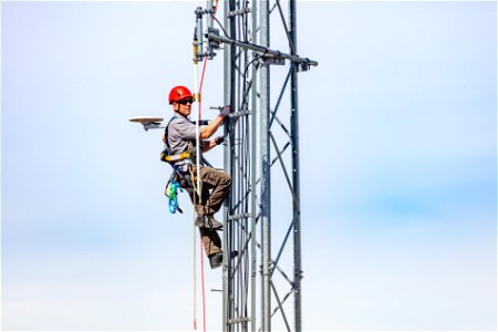 Dave Kelser, Electronics Technician, climbing a communications tower (3) photo