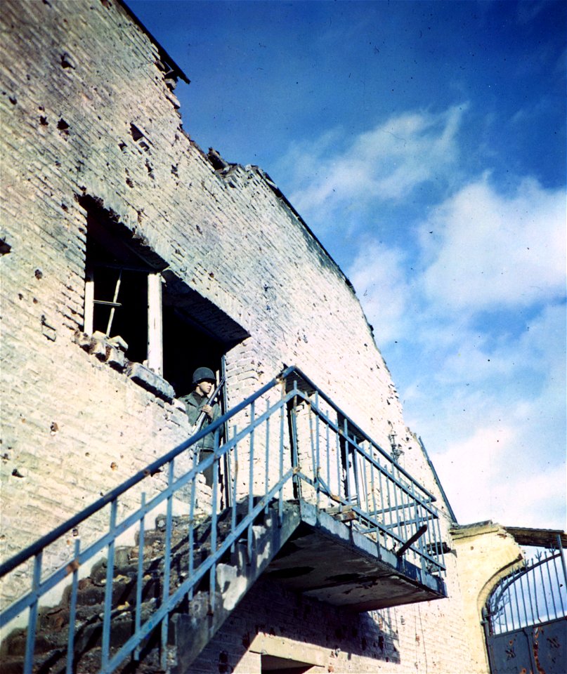 C-721 - An open balcony door is an observation post for Pfc. Charles E. Showe, Hagerstown, Maryland, of the 29th Inf. Div., near Schophoven, Germany.