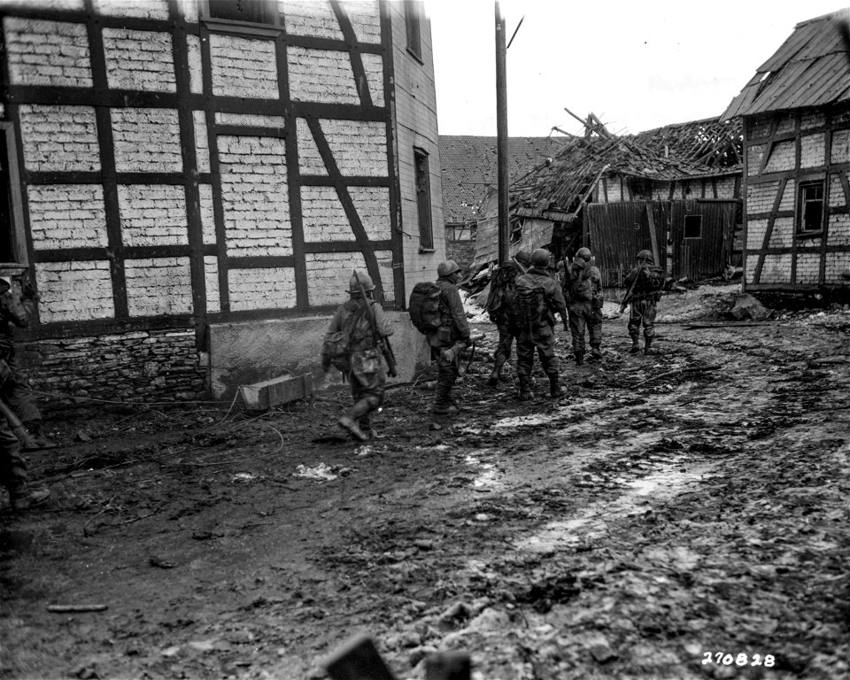 SC 270828 - Infantrymen of the 1st Bn., 60th Inf. Regt., 9th Inf. Div., U.S. First Army, advance through the town of Dreiborn, Germany, during the drive that netted them the town. 3 February, 1945.
