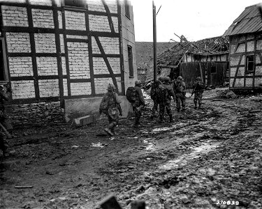 SC 270828 - Infantrymen of the 1st Bn., 60th Inf. Regt., 9th Inf. Div., U.S. First Army, advance through the town of Dreiborn, Germany, during the drive that netted them the town. 3 February, 1945. photo