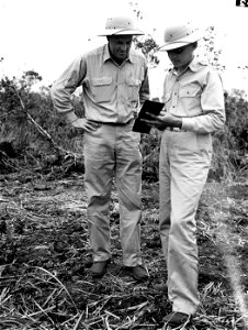 SC 151464 - While the pole line installation is primarily for military purposes, it is built to commercial specifications, and will be useful in peace-time. Here M/Sgt. J. J. Grant and Lt. E.B. Wheeler consult the book in Hawaii. photo