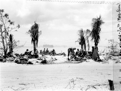 Beach scene showing LST beyond coral reef. Saipan. June, 1944.
