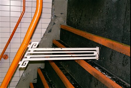 Handrail stancion at West Croydon, thought to date from the construction of the new station building, in about 1930.  The orange colour is that of the London Overground.