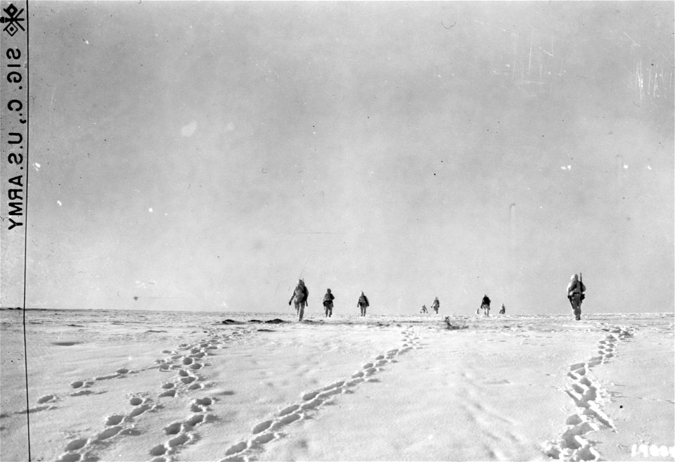 SC 198842 - An American infantry patrol, wearing snowsuits, advances over a hill near Dahl, Luxembourg. 14 January, 1945. photo