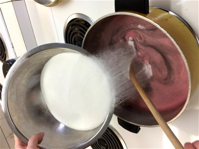 Adding sugar to grape jelly photo