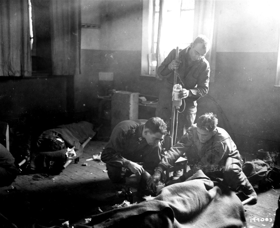 SC 199083 - Blood plasma is given to an American soldier at a battalion aid station.