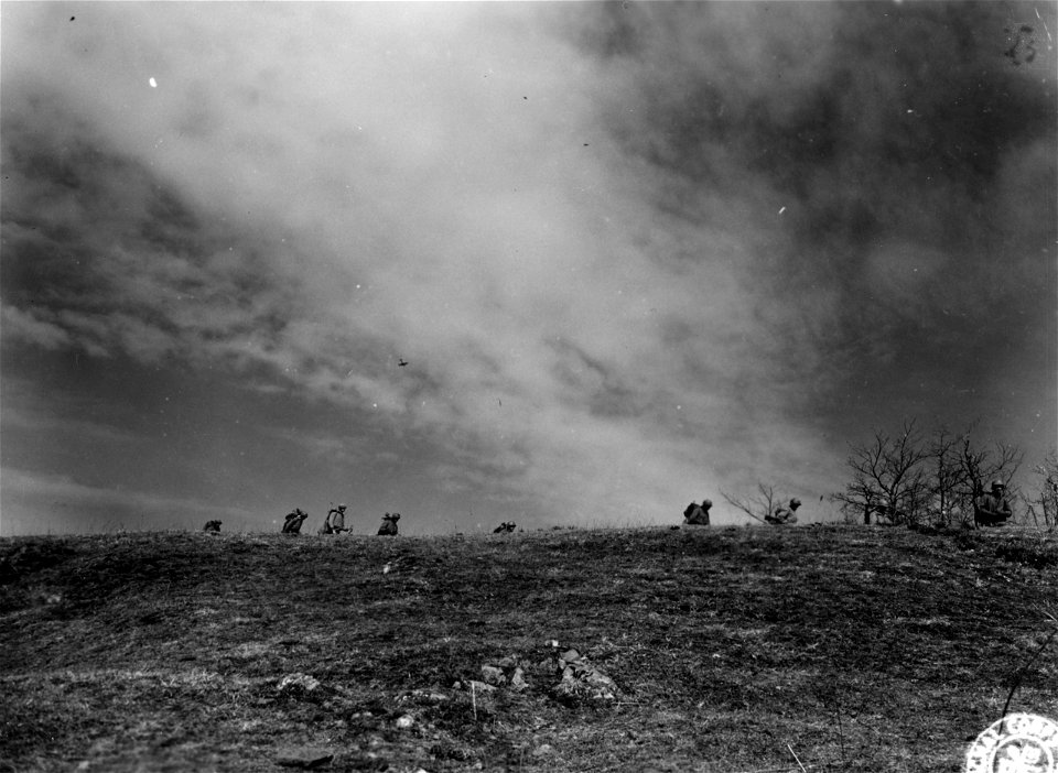 SC 270843 - Infantrymen of the 1st Bn., 35th Mtn. Inf., 10th Mtn. Div., across the skyline of Mt. Belvedere while a P-47 Thunderbolt fighter strafes and bombs enemy positions on the reverse slope of the mountain...