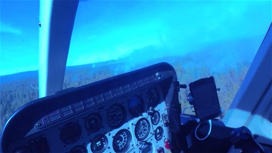 Crew Member Surveys Smokey Forest from a Helicopter