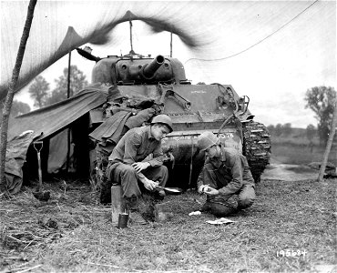 SC 195634 - Pvt. Harold Newlun, Long Bottom, Ohio, fries spuds while T/5 Oliver A. Woods, Ruston, La., peels.