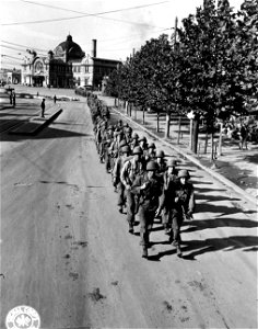 SC 270790 - The 32nd Inf. Regt., 7th Div., marches thru the streets of of Kyongsong to their barracks.