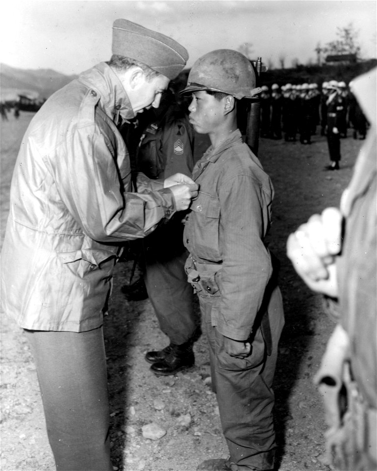 SC 364062 - Sec. of Army Frank Pace, Jr., pins the Silver Star medal on Sgt. Kim Choong Yul, 5th ROK Div., at ceremonies held at the Honchon Airstrip, Korea. 12 April, 1951.