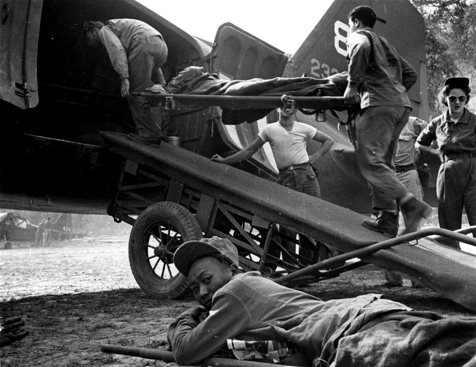 SC 184776-S - Orderlies from 25th Field Hospital loading wounded Chinese soldiers in to airplane.
