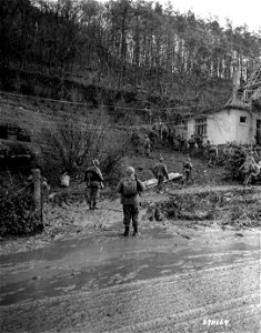 SC 270664 - U.S. infantrymen leave the muddy road to enter the the Hurtgen Forest, Germany, as they advance against German installations in the wooded area. 18 November, 1944.