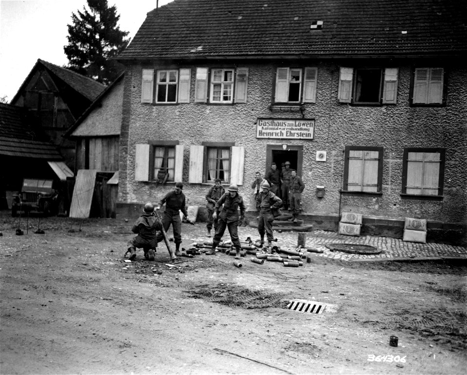 SC 364306 - 45th Division infantrymen fire 81mm mortar over house in Wingen. 15 December, 1944.