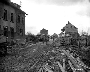 SC 270820 - Infantrymen of the 9th Division move into a small German town in support of the 3rd Armored Division. 25 November, 1944.