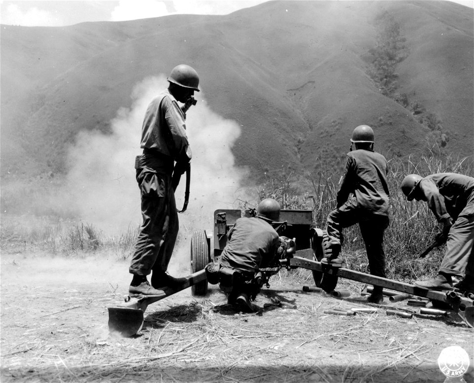 SC 364530 - 37mm anti-tank gun is shown firing cannister ammunition at Japs hidden in tall grass lining the road along route #5 between Yangiran and Bone Province. North Luzon, P.I. 2 June, 1945.