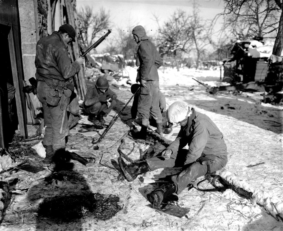 SC 364286 - Combat infantrymen of Company "A", 1st Battalion, 424th Regiment, 106th Infantry Division, First U.S. Army clean weapons in snow-covered Wanne.