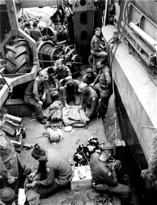 SC 374834 - Men packing infantry pack in preparation for traveling.