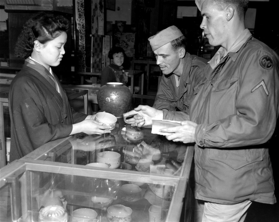 SC 221507 - Two GIs of the 27th Div. buying souvenirs with the aid of a Japanese phrase book. Niigata, Honshu, Japan. 21 October, 1945.