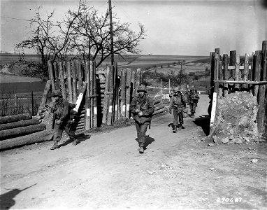 SC 270681 - Men of the 5th Inf. Div., U.S. Third Army, file through Nazi roadblock into the newly captured town of Corweiler, Germany. 16 March, 1945. photo