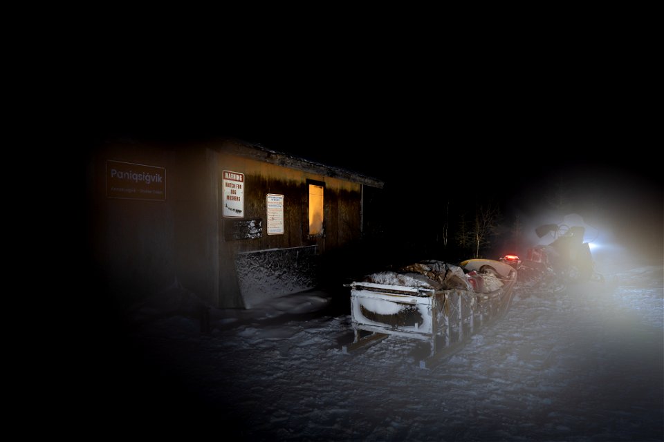 Snowmachine and sled at night