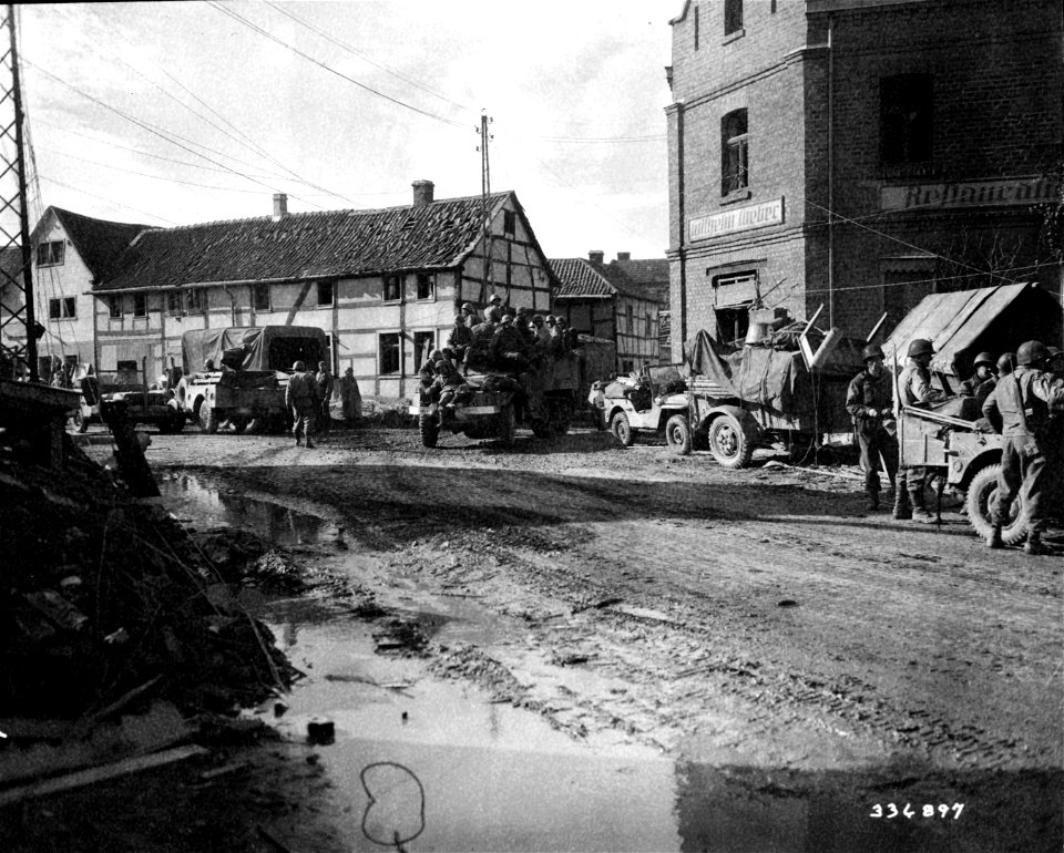 SC 336897 - Infantrymen of the 9th Armored Division, U.S. First Army, move through Vettweiss, Germany, on their way to cross the Neffel River to take Zulpich, Germany. photo