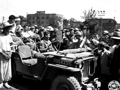 SC 270792 - Pfc. Philippe Durette, 24, of Maple Grove Ave., Maple Grove, Maine, member of the famous 7th Division, is surrounded by friendly Koreans when he parked his jeep for a minute on a street in Seoul, the capital of Korea. photo