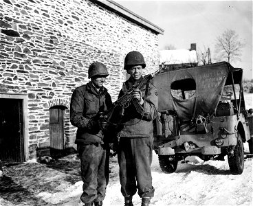 SC 364284 - Cpl. Jesse Donahu, Mullins, W.Va., left, and Lt. Robert W. Meyer, Mt. Vernon, N.Y., examine German machine pistol found abandoned in the woods near Monaville. photo