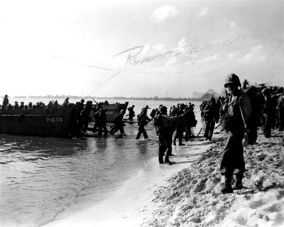 American assault troops emerge from their landing craft on the beach of Saipan the first day of the battle for the island in the Marianas. June, 1944.
