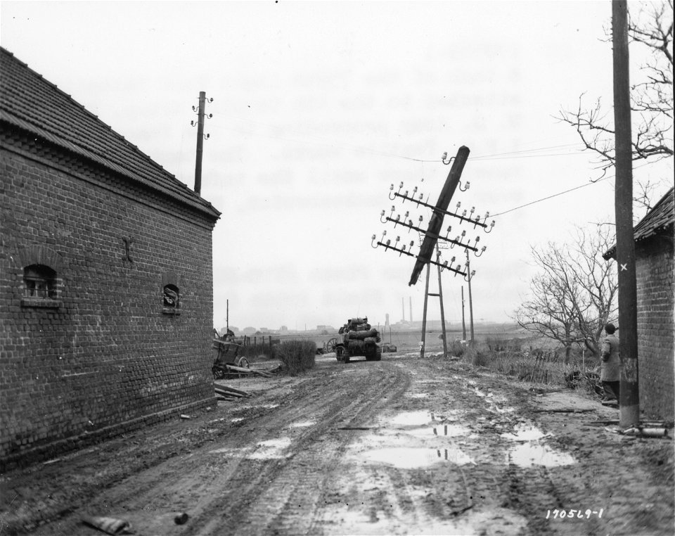 SC 170569-S - A tank of the 759th Light Tank Battalion, attached to the 4th Cavalry Group, First U.S Army, proceeding to the famous I.F.G. Textile Works.