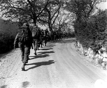 SC 270868 - Infantrymen of Co. "I", 3rd Bn., 85th Regt., 10th Mtn. Div., march in a column of file up the road to the trucks which will take them to more forward positions. 17 April, 1945.