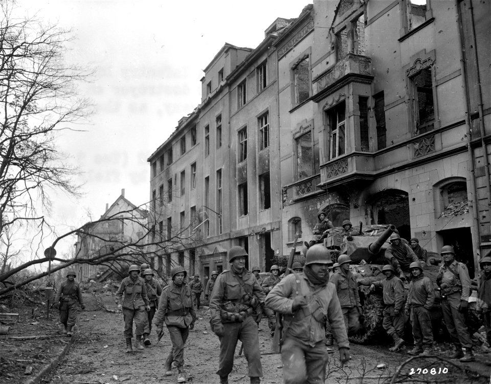 SC 270810 - Members of 1st Patrol of 8th Infantry Division, U.S. Army, pass a tank destroyer on street of battle-scarred Duren, Germany, as they enter heart of the city. 24 February, 1945.