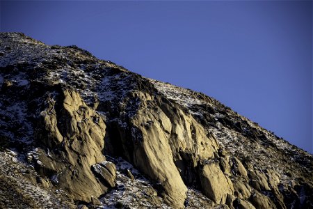 Snow over a rock formation near sunset photo