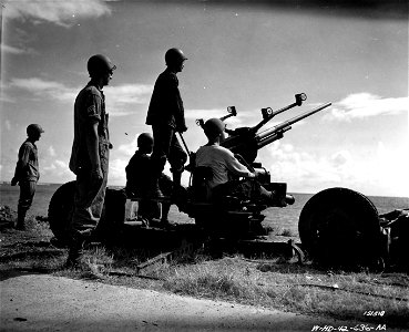SC 151518 - Crew manning a gun, keep watch at a coastal point for low-flying enemy planes during maneuvers. Hawaii. photo