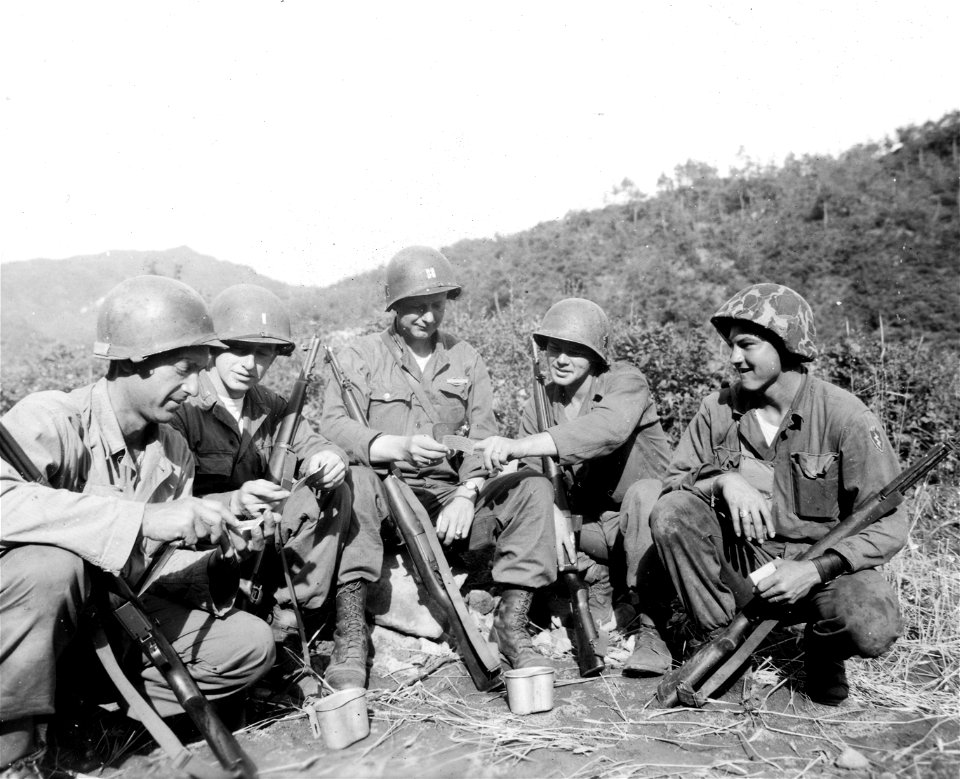 SC 374885 - Typical day of the many soldiers in Korea who observed Father's Day without ever having seen their offspring are these five men of the 25th U.S. Inf. Div., who get together to compare snaps of their youngsters.