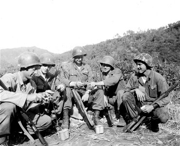 SC 374885 - Typical day of the many soldiers in Korea who observed Father's Day without ever having seen their offspring are these five men of the 25th U.S. Inf. Div., who get together to compare snaps of their youngsters. photo