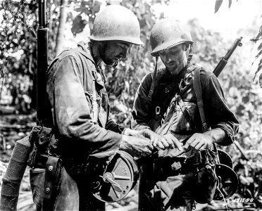 SC 171588 - At the fighting front two soldiers string wire for communications between the 127th Regiment Command Post and the 5th Portable Hospital of the 32nd Division. photo