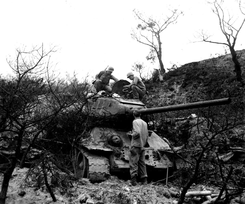 SC 348913 - L-R: Pfc. Walter W. Smith, Corrigan, Tex.; Pfc. Robert E. McMahan, Springfield, Tenn.; and Cpl. Hubert J. Hightower, Rome, Ga., all of 5th Cav. Regt., examine captured enemy tank which had been guarding the main road of Waegwan, Korea.