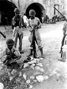 SC 364517 - Rookies of A Co., [censored] Inf., cleaning their newly issued Springfield rifles and carbines with hand-hewn bamboo cleaning rods.