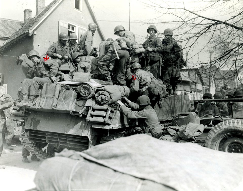 SC 270687 - 3rd U.S. Army infantrymen load onto tank destroyer in Konigstadien, Germany, as they drive deeper into Germany. 25 March, 1945.