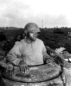 SC 196110-S- T/4 Claude Mann, Chicago, ILL, is the driver of an M-4 tank attached to a motor transport unit, near Nacy, France. 5 November, 1944.
