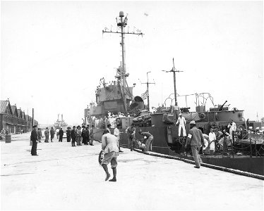 SC 364347 - Japanese dock workers help with the lines at the PCER 949 docks at Tokyo, the first American ship to enter the harbor.