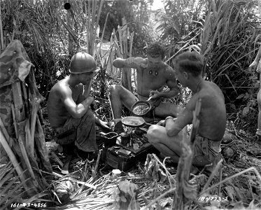 SC 184773-B - Battle-hardened members of a U.S. Army Special Weapons unit take time out after the first excitement of landing on landing on Bougainville Island in the South Pacific to make a batch of fudge. photo
