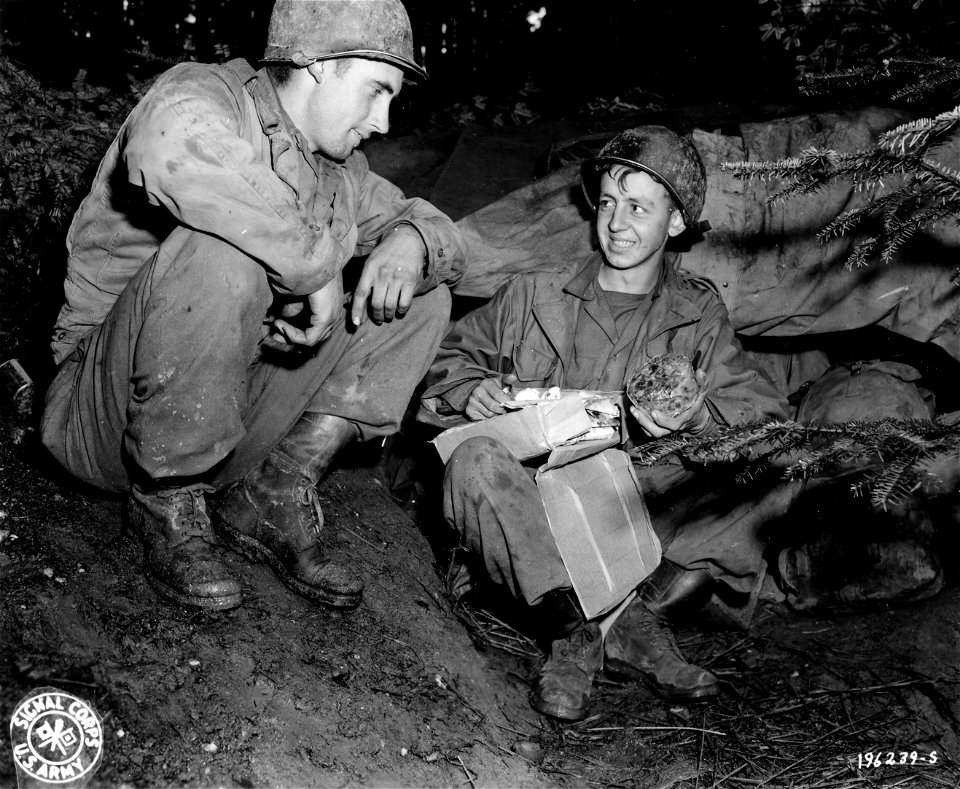 SC 196239-S - S/Sgt. Thomas E. Bohanon, Colman, Texas, of the 132nd Field Artillery Battalion, ogles fruit cake just received in a Christmas package...