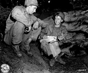 SC 196239-S - S/Sgt. Thomas E. Bohanon, Colman, Texas, of the 132nd Field Artillery Battalion, ogles fruit cake just received in a Christmas package... photo